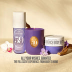 Three Sol Janeyro 59 Aged scented products arranged on a beige textured surface: a translucent lavender bottle, a purple candle with a gold circular label, and a purple body butter jar with a white lid. Decorative orchid flowers and dried wood are placed around them, with the text 'ALL YOUR WISHES, GRANTED THE FULL SCENT EXPERIENCE, FROM BODY TO HOME' at the bottom.