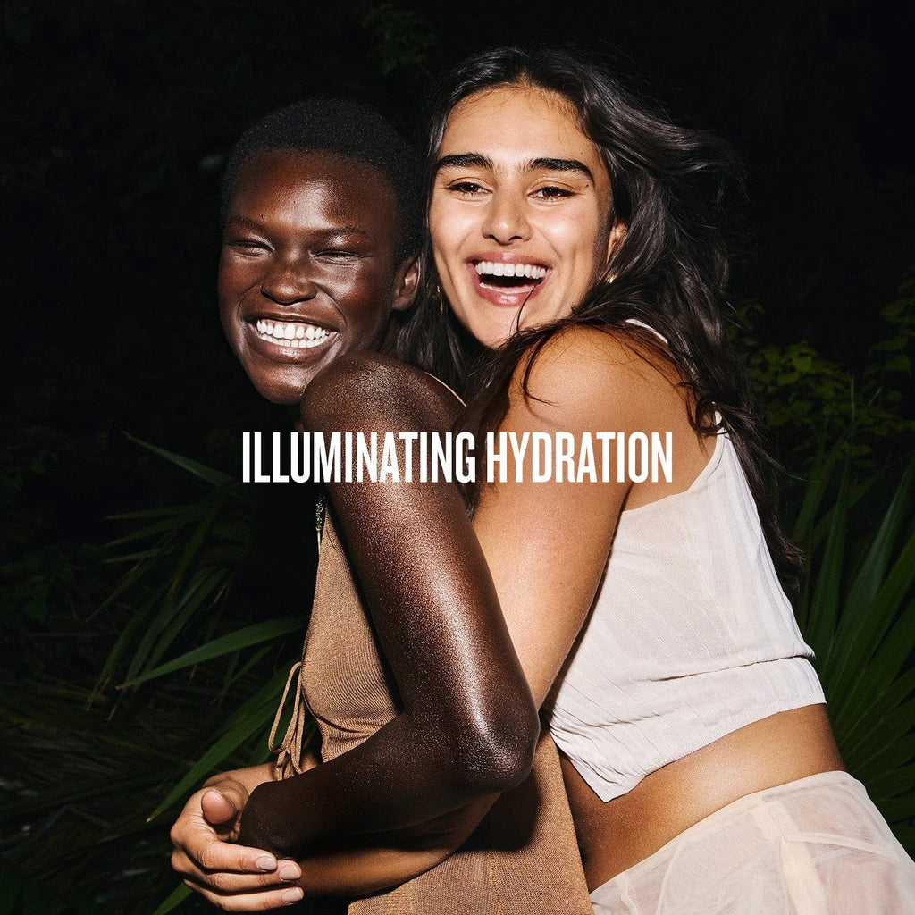 text on image reads illuminating hydration. This image is of two models miling and looking glowy wearing sol de janeiro glowmotions glow body oil