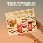 A gift set box held by two hands, featuring the brand name SOL DE JANEIRO and holiday-themed illustrations of a body brush, body cream, and body wash. The box is set against a warm gradient background with promotional text at the top.
